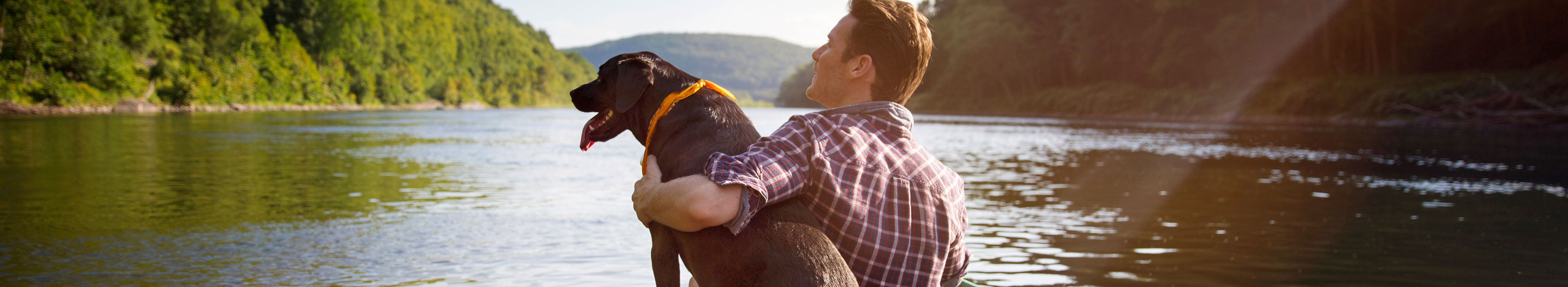 Mann mit Hund in einem Kanu