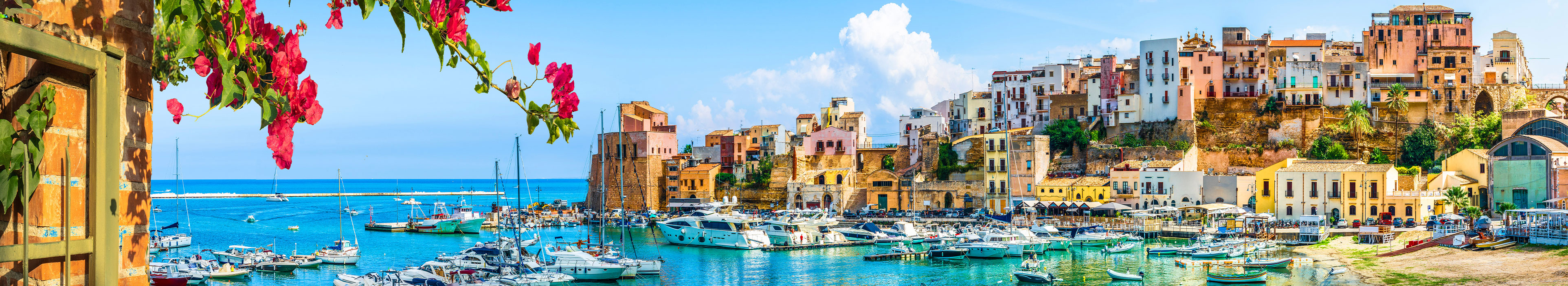 Urlaub Sizilien. Bunte Häuser mit Blick auf den Hafen. 