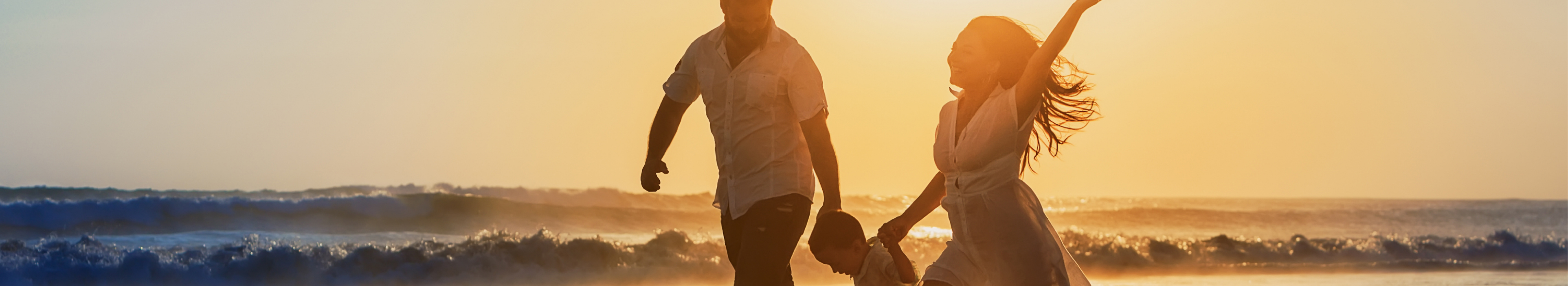 Glückliche Familie - Vater, Mutter, Baby Sohn halten Hände und laufen mit Spaß entlang Rand des Sonnenuntergangs Meer auf schwarzem Sandstrand. Aktive Eltern und Menschen, Outdoor-Aktivität auf tropischen Sommerferien mit Kindern auf Jamaika