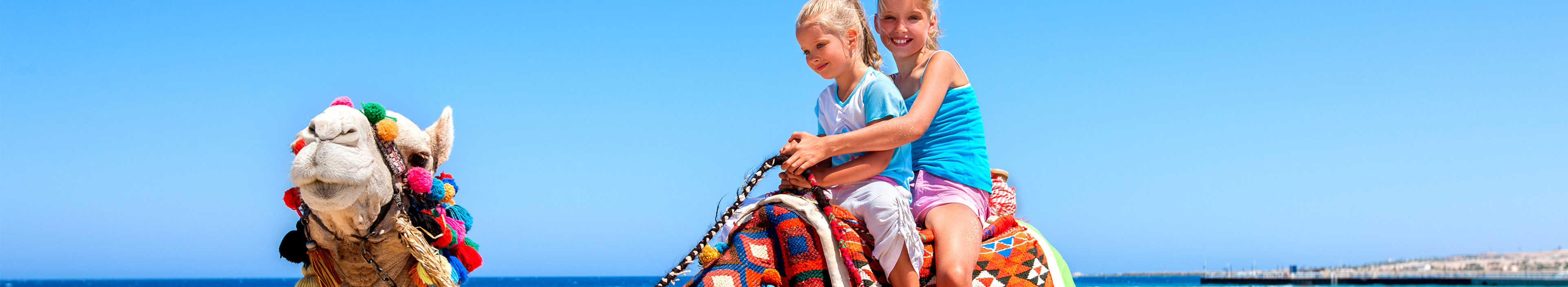 Zwei Mädchen sitzen auf einem Kamel in Ägypten