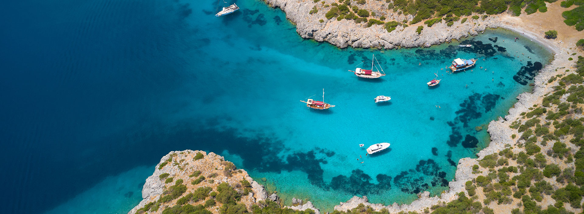 Marineyacht im Meer und halbe Unterwasseransicht des Meeresbodens in Bodrum, Türkei.