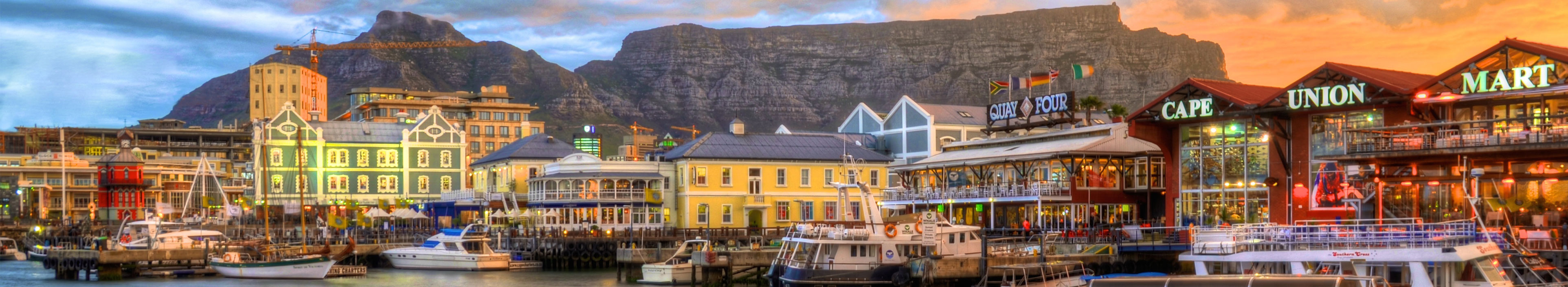 Blick auf Kapstadt, Südafrika mit Bergen im Hintergrund und einer Wasserfront im Vordergrund.