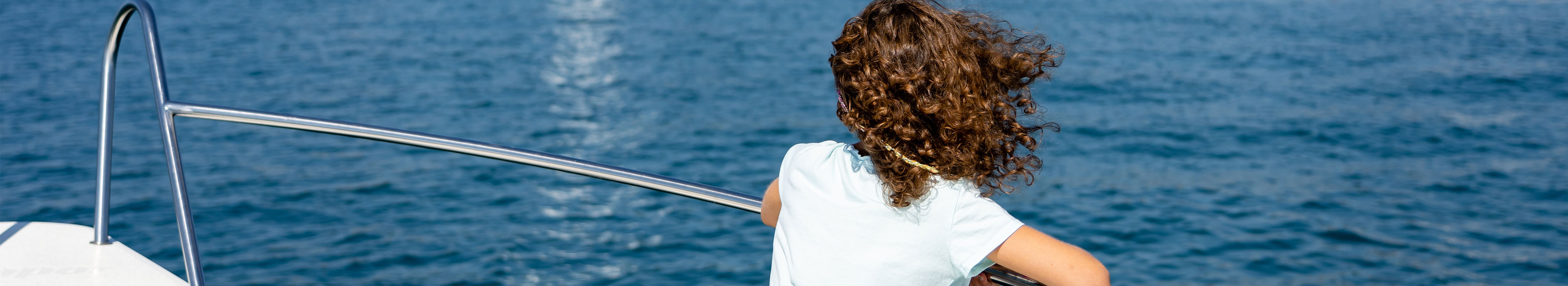 Kind sitzt in Langenargen am Bodensee auf einem Boot. 