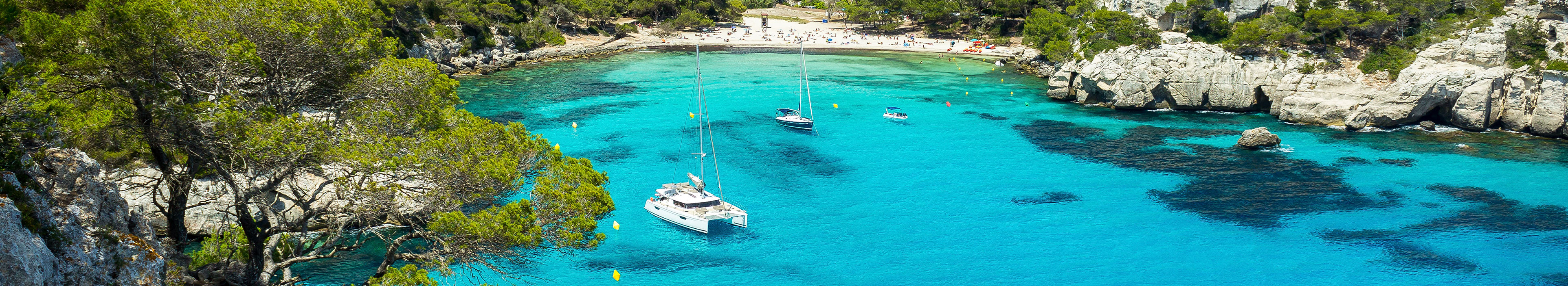 Urlaub Mallorca. Bucht umgeben von grünen Pinienwäldern.