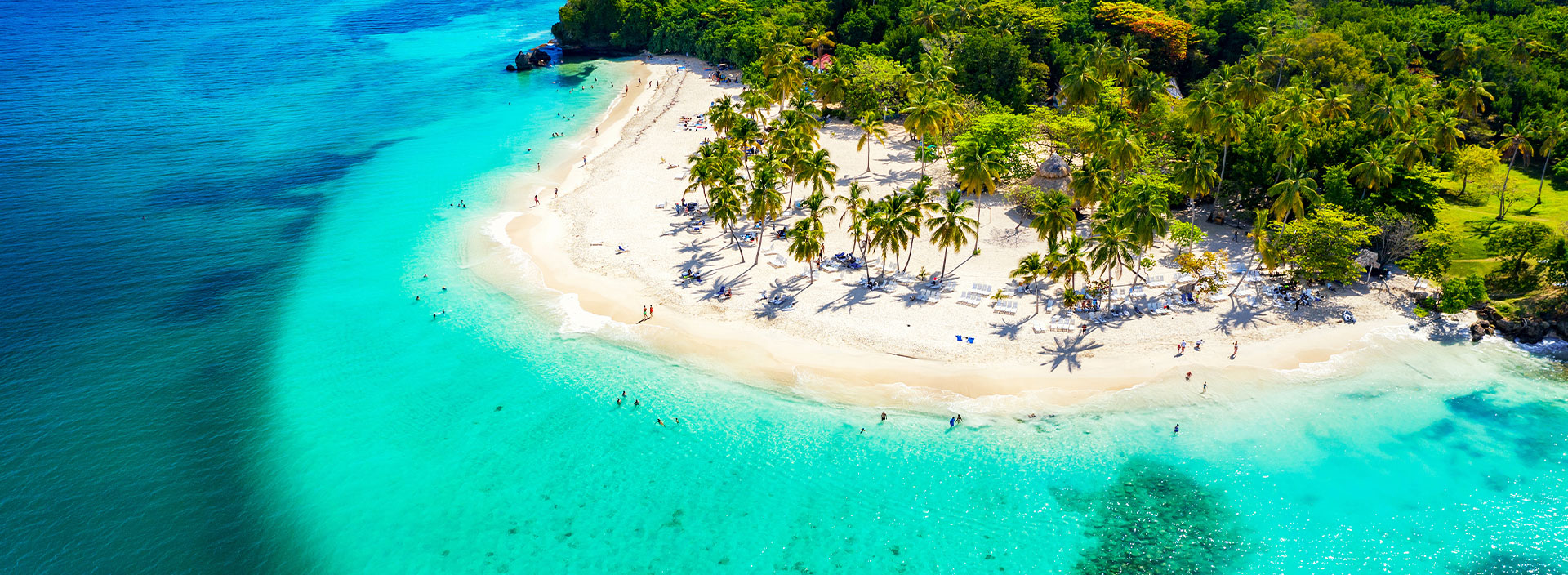 Urlaub Karibik. Weißer tropischer Sandstrand mit grünen Palmen und türkisblauem Meer.