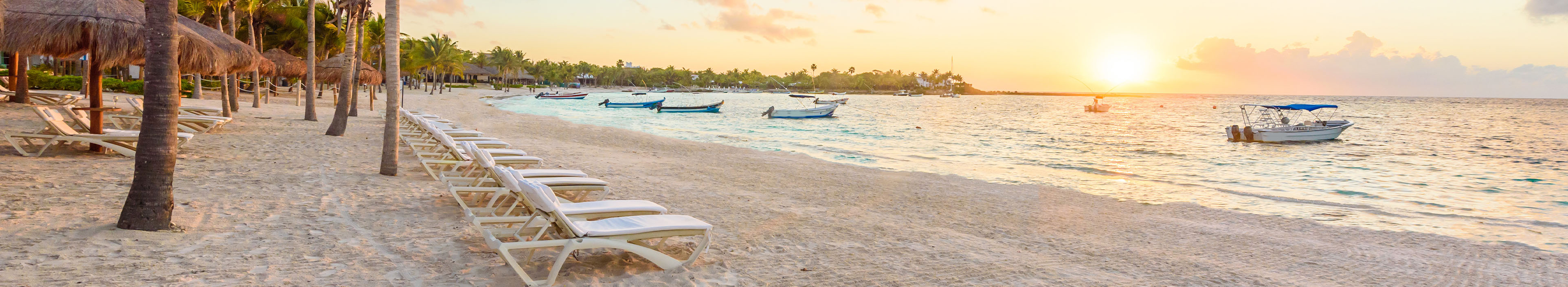 Strand mit Liegen und Palmen in Mexiko