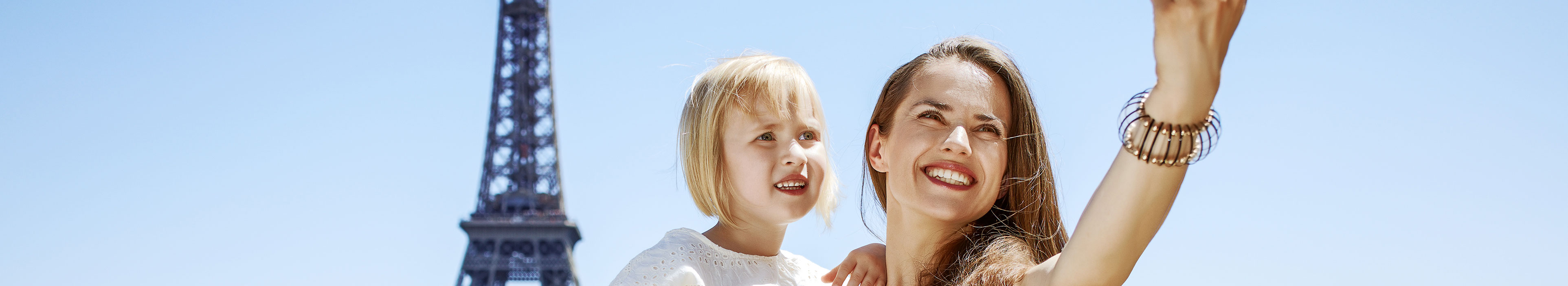 Mutter und Kind machen ein Selfie vor dem Eiffelturm