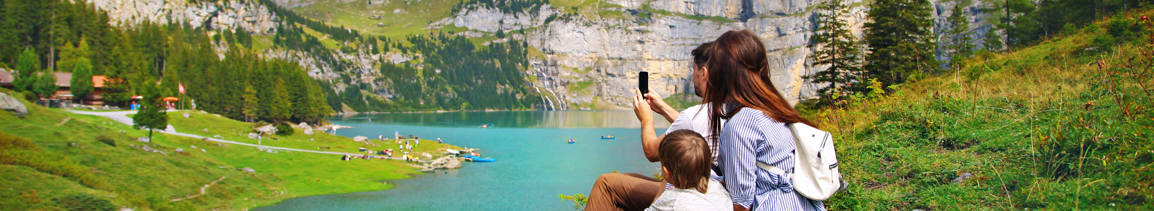 Eine junge glückliche Familie beim Fotografieren der Natur am Oeschinensee, in der Schweiz.